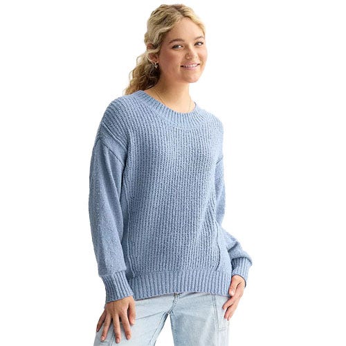 A person wearing a light blue knit sweater and light blue jeans.