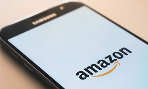 an image of a cell phone displaying the amazon app on a beige background