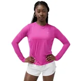 A person wearing a pink long-sleeve athletic top with a small logo, paired with white shorts.