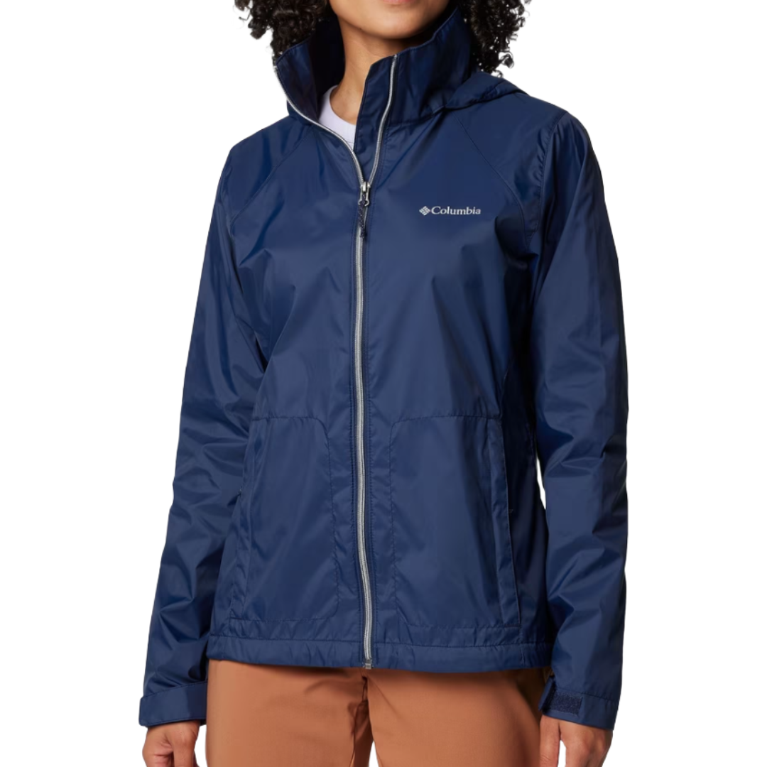 A woman is wearing a blue Columbia zip-up jacket with a hood, paired with brown pants.