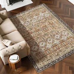A beige and cream Persian-style area rug with floral and geometric patterns is placed on a herringbone hardwood floor beside a light beige sofa and a small wooden side table.