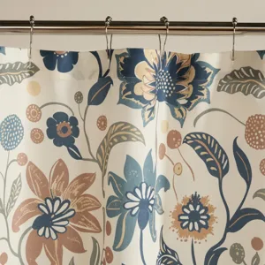 A floral-patterned shower curtain with blue, beige, and brown flowers and leaves hangs from a metal rod with hooks.