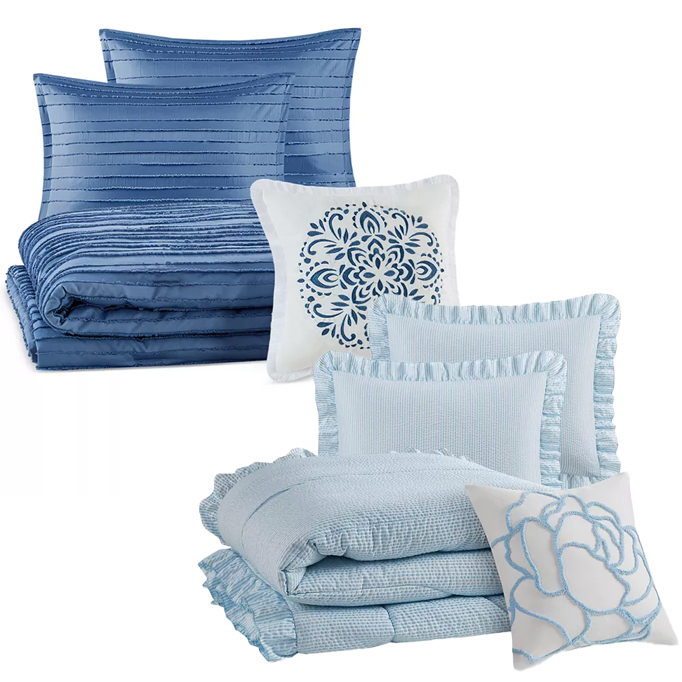 Bedding set with blue and white pillows and quilts in varied textures and patterns.