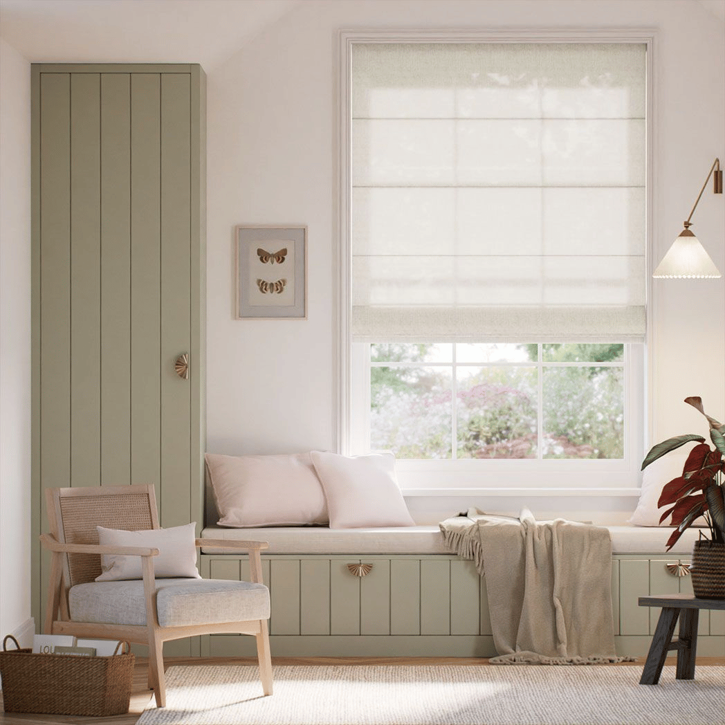 A cozy room with a cushioned window seat, a built-in wardrobe, a rattan armchair, and a small side table. The decor includes soft neutral tones, a wall-mounted light, and botanical accents. A framed butterfly art piece adds a decorative touch.