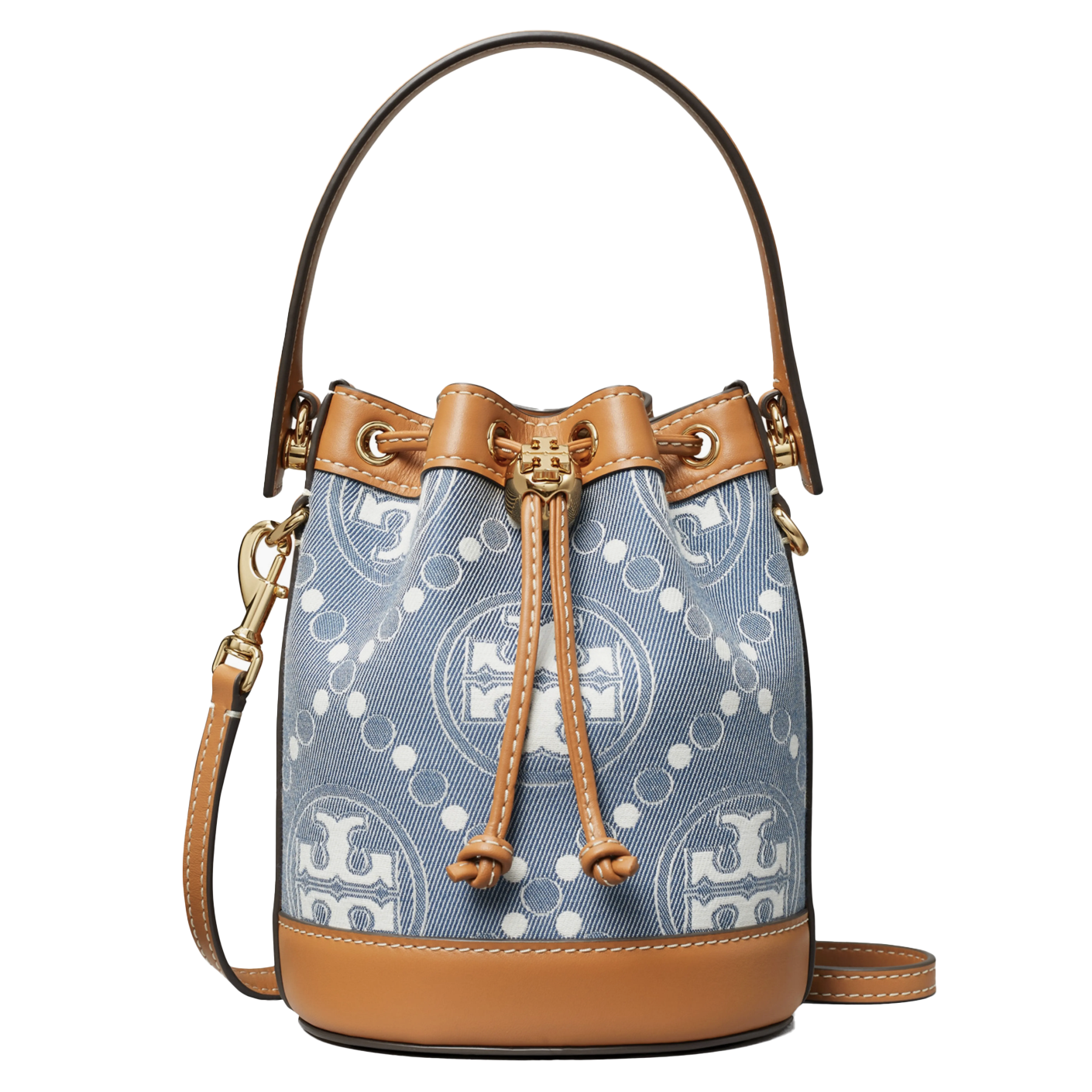 Tory Burch Mini Denim Bucket Bag features a blue denim exterior with a geometric logo pattern, tan leather trim, adjustable strap, and drawstring closure.