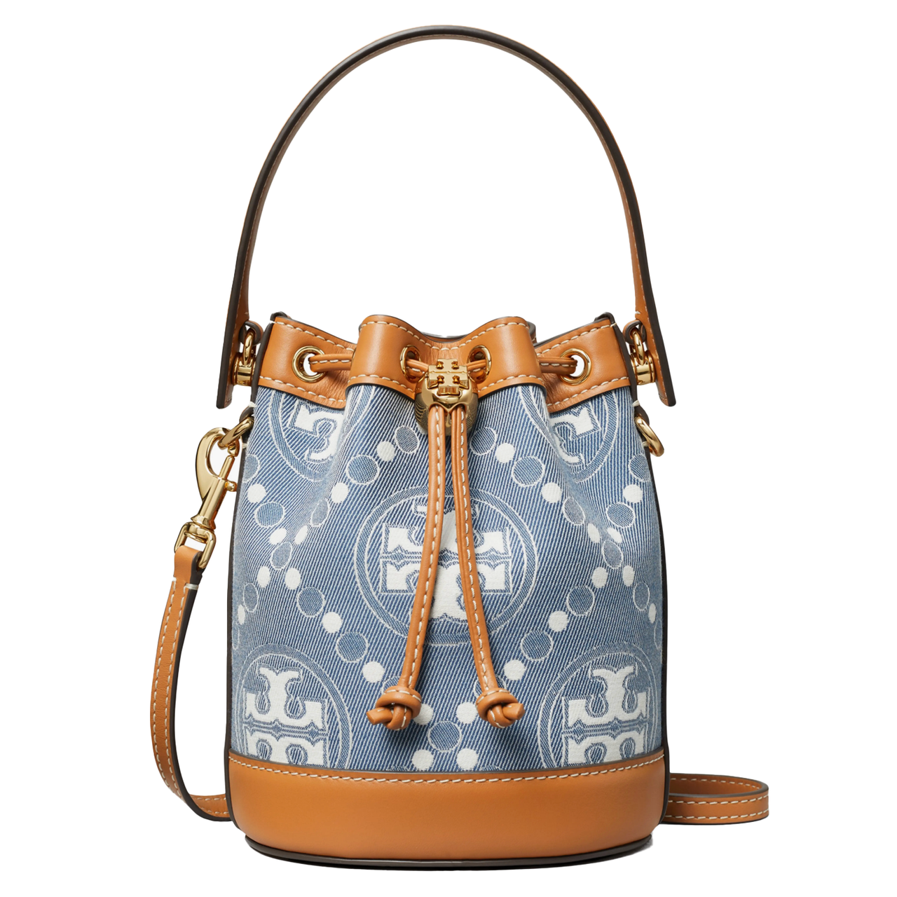 Tory Burch Mini Denim Bucket Bag features a blue denim exterior with a geometric logo pattern, tan leather trim, adjustable strap, and drawstring closure.