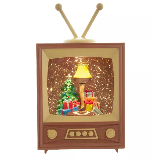 A vintage-style TV decoration with a Christmas scene inside, featuring a tree, gifts, and a leg-shaped lamp with fishnet stockings.