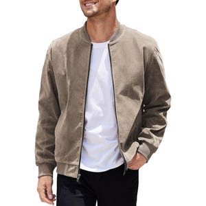 A man wearing a beige suede bomber jacket over a white t-shirt paired with black pants.