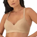A woman is wearing a beige, wireless bra with wide straps and seamless cups, providing a smooth look and support.