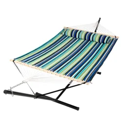 A striped fabric hammock with a coordinating pillow is supported by a black metal stand, featuring a wooden spreader bar and connected by white ropes and a chain.