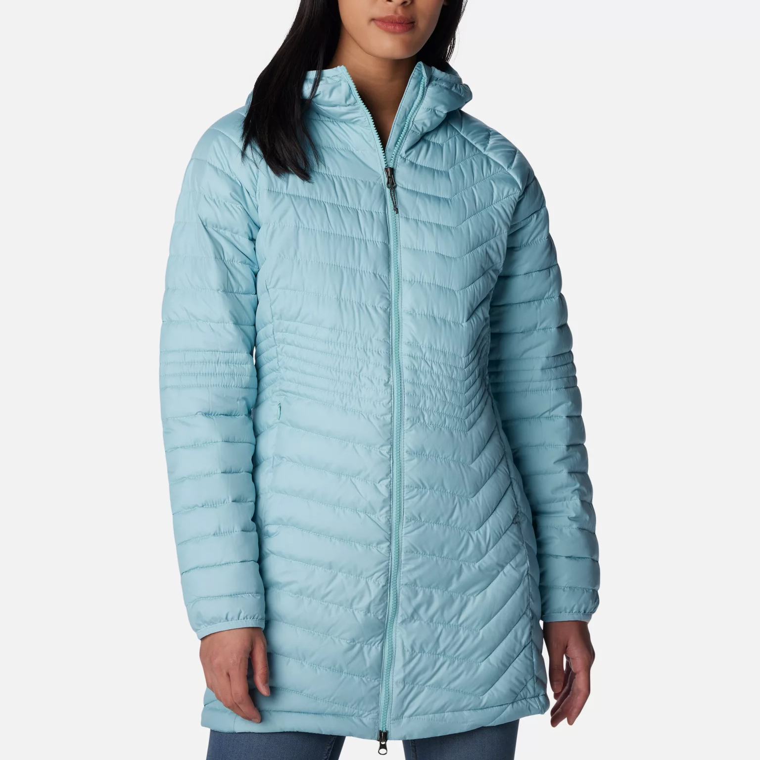 A woman wearing a light blue quilted jacket with a zip front and high collar.