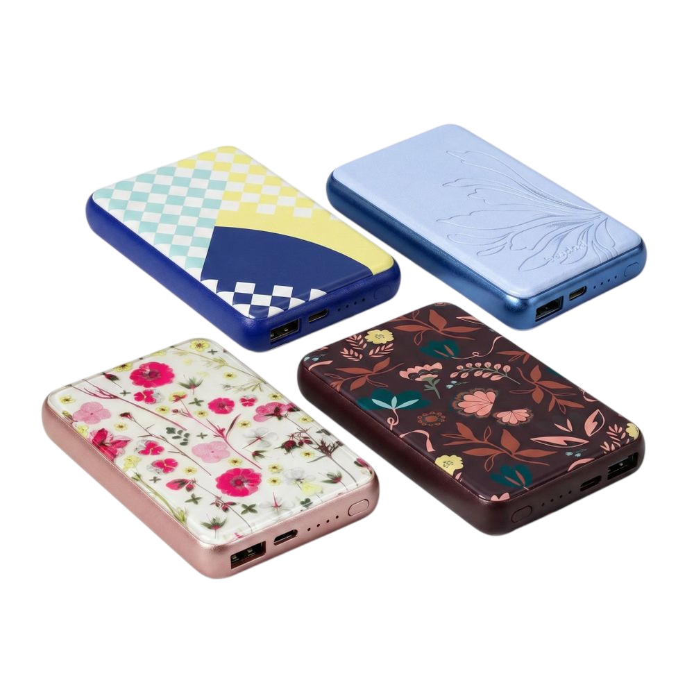 Four portable power banks with USB ports, each featuring different designs: a geometric pattern, a raised floral motif, bright floral prints on a pink base, and dark floral patterns on a maroon base.