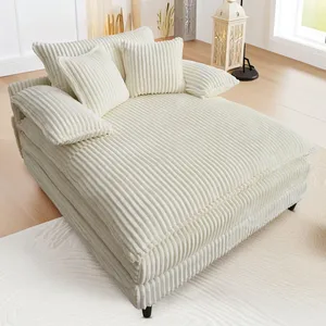 Cream-colored corduroy sectional lounge chair with multiple cushions, set in a cozy room with light wood floors and natural decor accents.