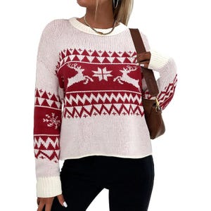 A cozy white and red crewneck sweater featuring a festive pattern with reindeer and snowflakes. The sweater has long sleeves with ribbed cuffs, adding a classic winter touch.