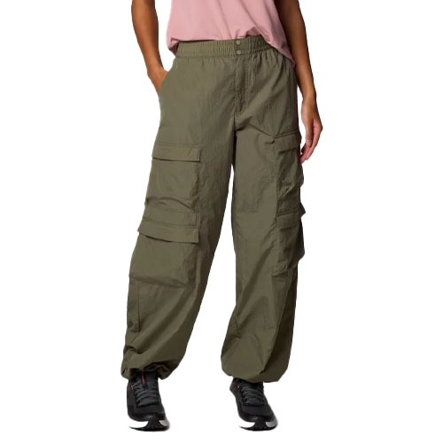 A person is wearing loose-fitting, olive-green cargo pants with multiple pockets and black shoes, paired with a pink top.