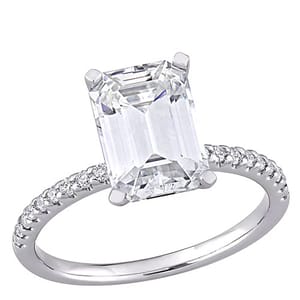 A solitaire engagement ring featuring an emerald-cut diamond with a band adorned with smaller round diamonds.