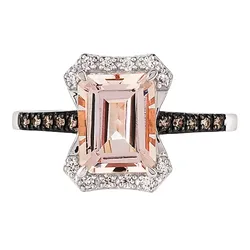 A rectangular morganite gemstone ring set in a white metal with a diamond halo and a band accented with smaller stones.