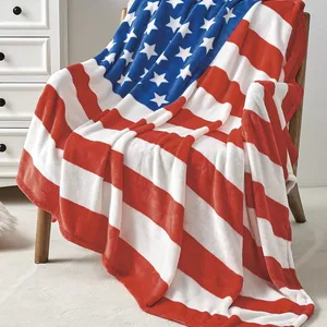 A fleece blanket featuring an American flag design with red and white stripes and a blue field with white stars draped over a chair.