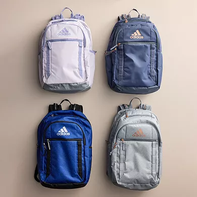 Four Adidas Excel 7 Backpacks are displayed in different colors: lavender, navy, royal blue, and gray, each featuring multiple pockets and the Adidas logo.