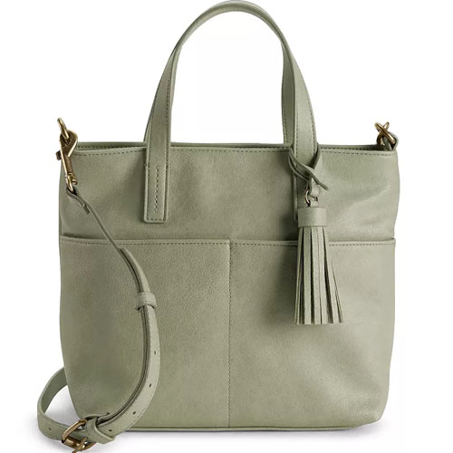 A light green handbag with a tassel detail, featuring a top handle and adjustable shoulder strap for versatile carrying options.