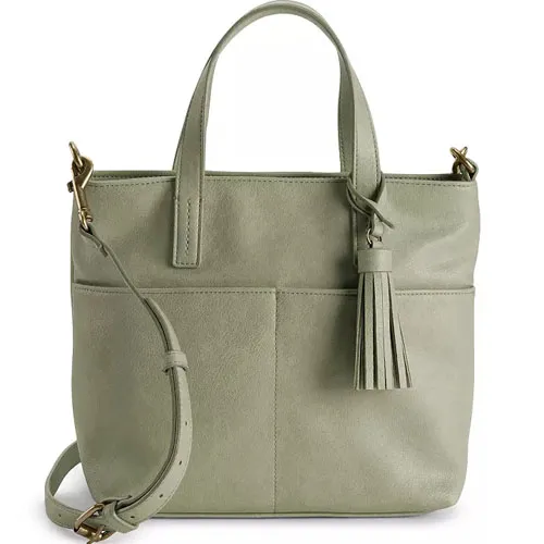 A light green handbag with a tassel detail, featuring a top handle and adjustable shoulder strap for versatile carrying options.