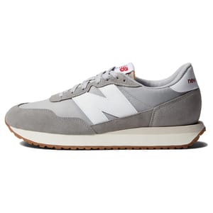 A gray suede and mesh New Balance men's classic sneaker, featuring a white \“N\“ logo, a cushioned sole, and gum rubber outsole, combining retro style with modern comfort.