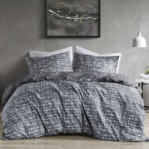 A bed features a comforter and pillowcases with a black-and-white textured pattern. A modern abstract painting hangs above, and a white pendant light and small side table complete the setting.