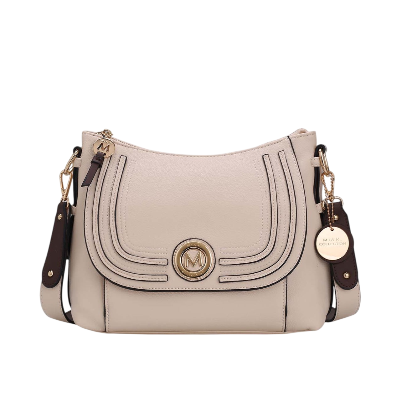 A beige crossbody handbag with dark brown accents and gold hardware, featuring a decorative \“M\“ emblem and a detachable shoulder strap.