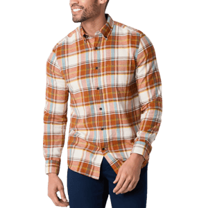 A man is wearing a long-sleeved plaid flannel shirt with hues of orange, yellow, and white, accented with blue pants.