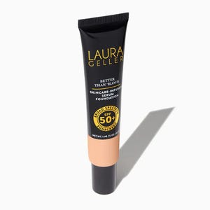 Black tube of Laura Geller foundation with peach-colored label, offering SPF 50 protection and skincare-infused benefits.
