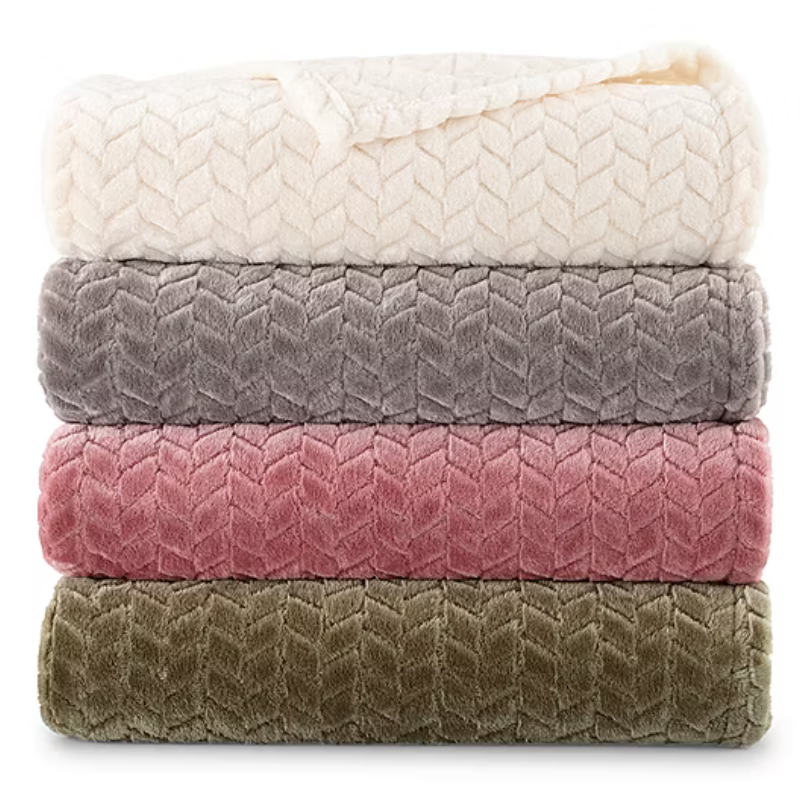 Stack of four plush blankets in cream, gray, pink, and olive green shades with a chevron pattern.