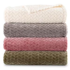 Stack of four plush blankets in cream, gray, pink, and olive green shades with a chevron pattern.