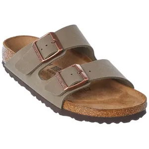 A sandal featuring a tan footbed, dual adjustable straps, and copper-colored buckles.