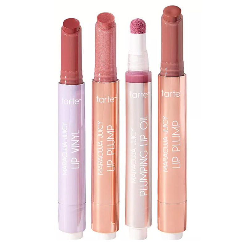 Four assorted Tarte lip products in cylindrical tubes: Maracuja Juicy Lip Vinyl, Lip Plump, Plumping Lip Oil, and another Lip Plump. Colors range from mauve to peach.