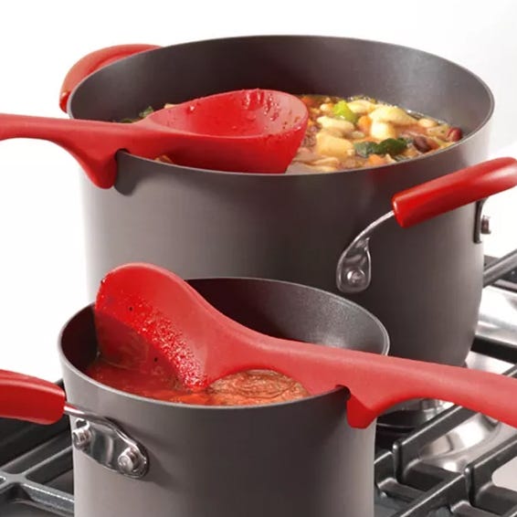 Two silicone cooking utensils with notches to rest on pot edges, preventing drips on the countertop; one is a spoon and the other is a ladle, both with red handles.