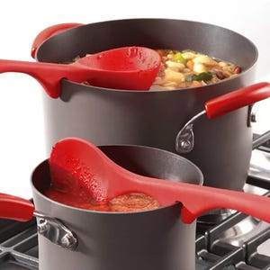 Two silicone cooking utensils with notches to rest on pot edges, preventing drips on the countertop; one is a spoon and the other is a ladle, both with red handles.