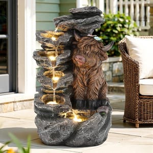 A garden water fountain features cascading LED-lit water over stone-like tiers with a decorative Highland cow sculpture on one side.