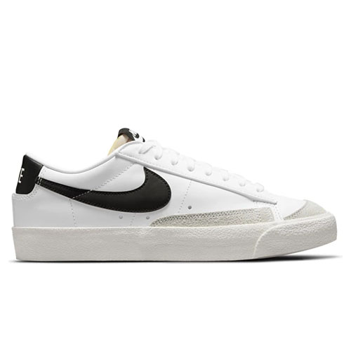 The Nike Blazer '77 Low Shoes are white with a black swoosh, featuring a low-top design, lace-up closure, and a rubber sole with textured details on the side.