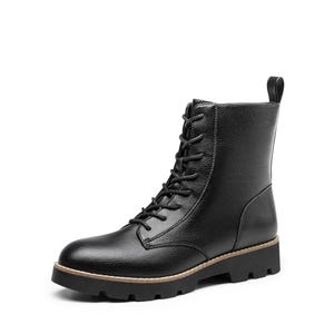Black leather combat boots with a lace-up front, a pull tab at the back, and a contrasting tan rubber sole.