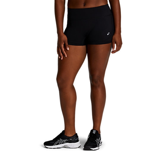 A person wearing black athletic short shorts with a small logo on the side and black running shoes featuring a white sole.
