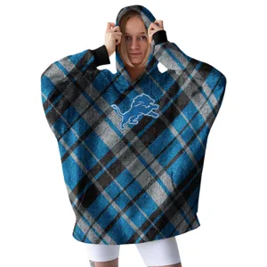 A woman wears a cozy plaid hoodie featuring a blue lion logo, paired with white leggings.