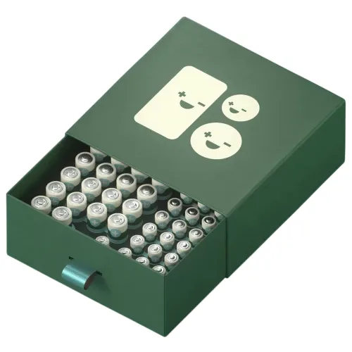 A green drawer-style box containing multiple AA batteries, decorated with minimalist smiling face graphics on the lid.