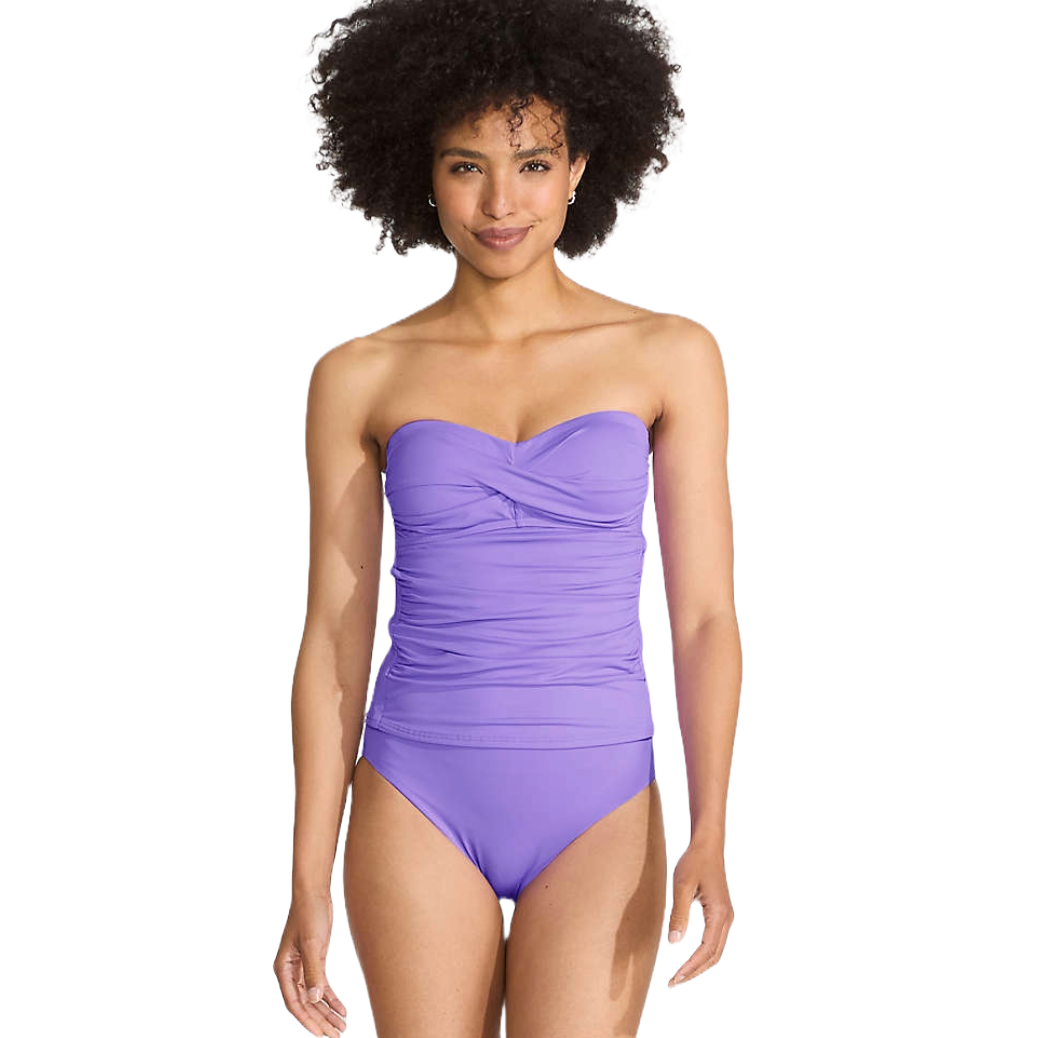 A strapless, ruched purple one-piece swimsuit worn by a person with curly hair.