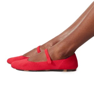 A pair of Rothy's Square Mary Jane flats featuring a vibrant red color with a classic strap across the top, made from sustainable materials on a slim flat sole.