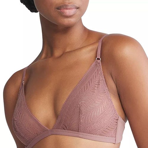 Woman wearing a lace-patterned, mauve bra with adjustable straps.