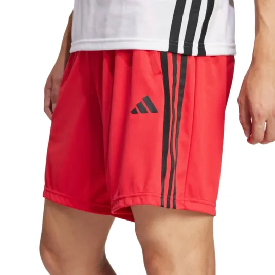 Red athletic shorts with black stripes and an Adidas logo on the left side, worn by a person standing.