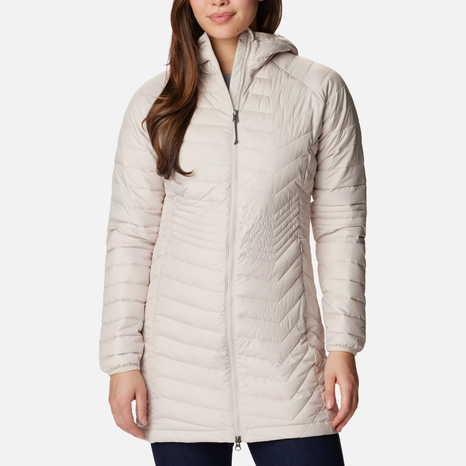 A woman wearing a light-colored hooded puffer coat.