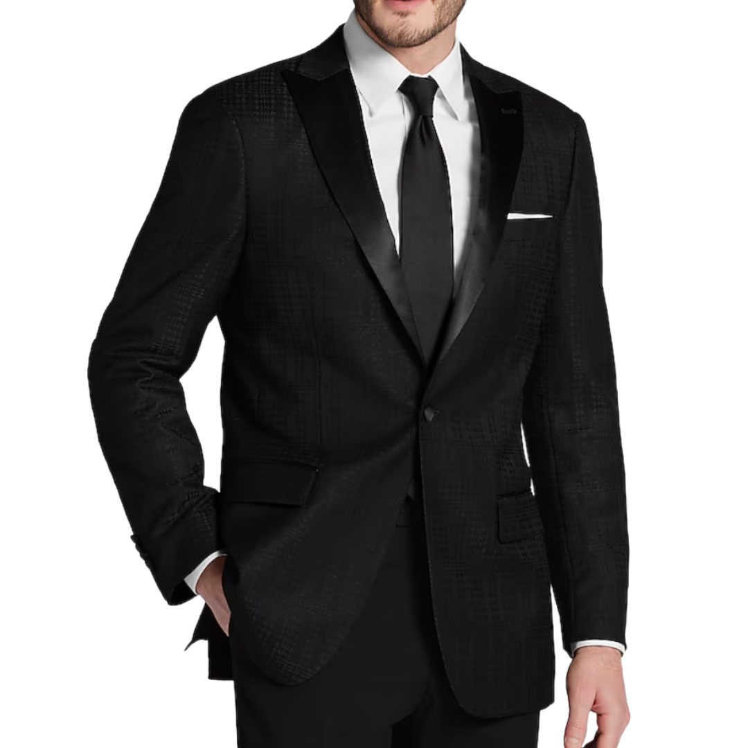 A man is wearing a textured black suit with a satin lapel, paired with a white dress shirt, black tie, pocket square, and dark trousers.