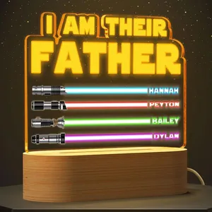 A lit sign displays \“I AM THEIR FATHER\“ above four lightsaber designs with names: Hannah (blue), Peyton (red), Bailey (green), and Dylan (purple).