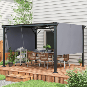 A 12' x 10' steel pergola with adjustable fabric panels for shade is set up on a wooden deck outside a house. It features a dining table with six wicker chairs and a rolling cart with tableware, surrounded by plants.